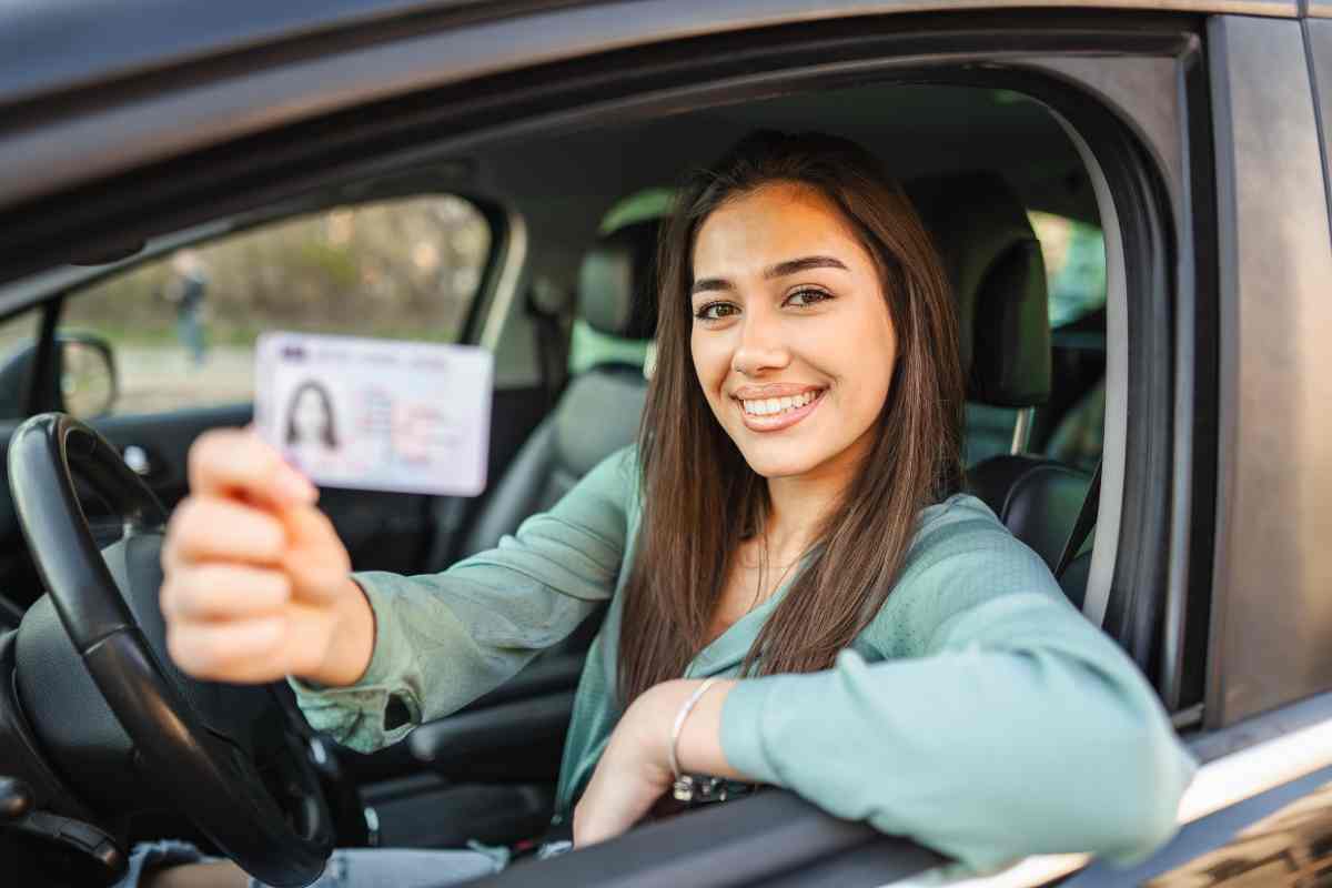 Una ragazza in auto mostra la sua patente
